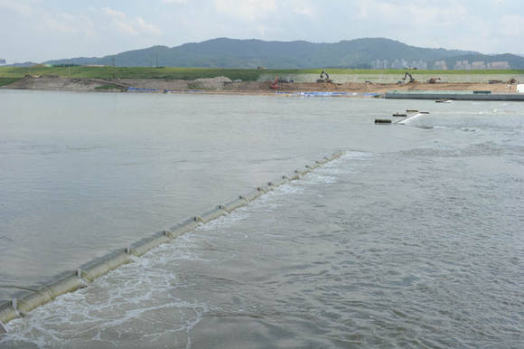 ▲ 메말랐던 금강에 설치된 금남보 위로 일정 수위를 넘어선 강물이 넘치고 있다. 멀리 강변세서 작업중인 포크레인만 보면 토목공사같지만, 강변 수변공간, 생태하천, 식생매트 등 다양한 환경관련 공사이다.