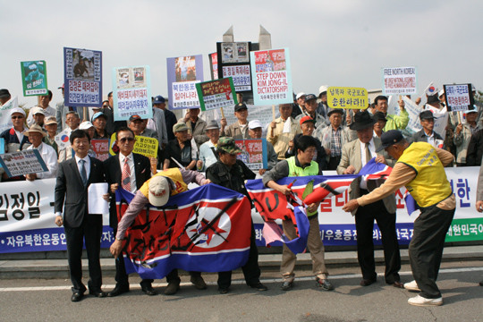 ▲ 어버이연합 등 회원들이 대북 전단 날리기에 앞서 북한 인공기를 찢고 있다.ⓒ뉴데일리