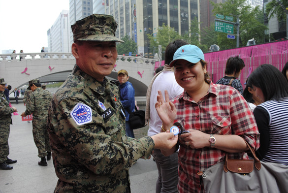 ▲ 보수단체 회원들은 청계광장에서 태국인 관광객에서 G20 성공기원 뱃지를 나눠주고 있다. ⓒ 뉴데일리