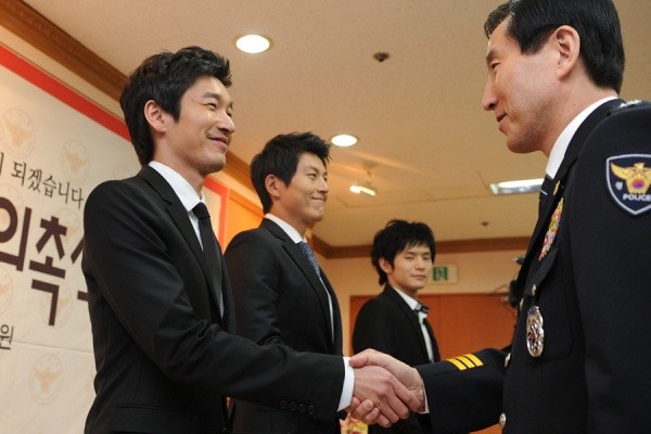 ▲ 조현오 경찰청장으로부터 명예경찰관 위촉장을 건네 받은 뒤 악수를 나누고 있는 배우 조승우.  ⓒ 김상엽 기자