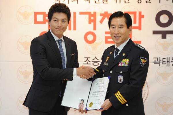 ▲ 배우 류수영이 조현오 경찰청장으로부터 명예경찰관 위촉장을 받은 뒤 악수를 나누고 있다.  ⓒ 김상엽 기자