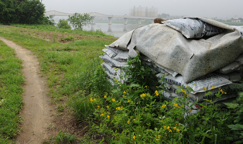 ▲ 하천부지 농경지에 쌓여있는 비료포대들.ⓒ