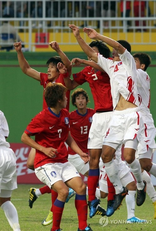 ▲ 8일 중국 광저우 웨슈산 스타디움에서 열린 아시안게임 축구 예선 남북대결에서 양팀 선수들이 공을 향해 뛰어오르고 있다.  ⓒ 연합뉴스