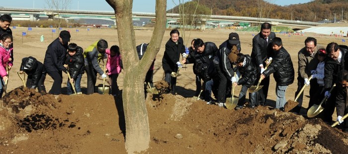 ▲ 김춘석 여주군수(오른쪽끝)와 한나라당 이범관 의원(오른쪽에서 두번째 어른)등 관계자들과 어린이들이 모여 이포 공원에서 팽나무를 심고 있다.
