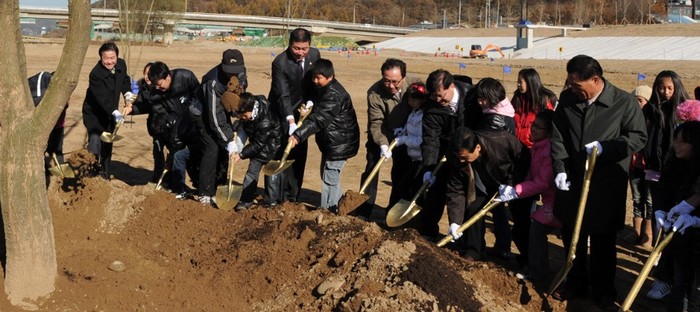 ▲ 이범관 의원(가운데 회색 옷)이 어린이와 관계자들과 기념식수를 하고있다.