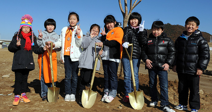 ▲ 나무를 심고 기념촬영을 하고 있는 어린이들.