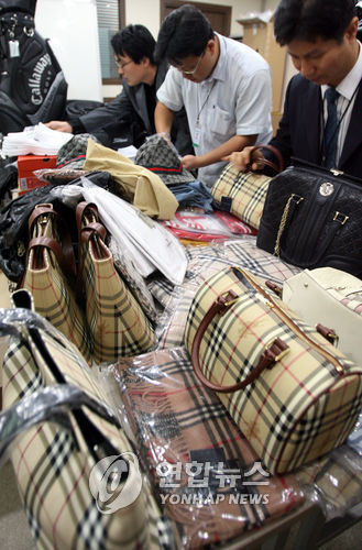 ▲ ⓒ 지난 2006년 10월 서울지방경찰청 사이버수사대 경찰들이 국내 인터넷 쇼핑몰에서 '오픈마켓' 형태로 입점한뒤 해외 유명 상표를 부착해 판매하던 '짝퉁' 명품 브랜드 제품들을 압수, 공개하고 있다.
