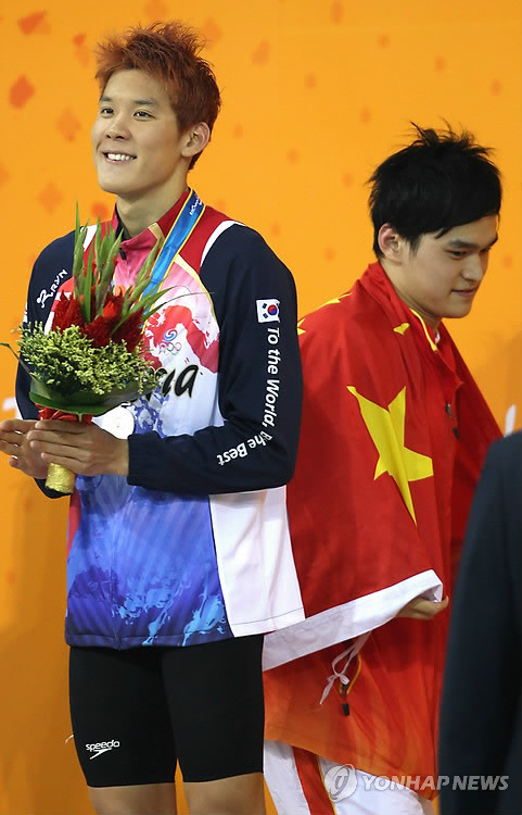 ▲ 18일 아오티 아쿠아틱센터에서 열린 아시안게임 남자 자유형 1500m 시상식에서 박태환 뒤로 금메달을 딴 중국의 쑨양이 지나가고 있다. 박태환은 은메달에 머물러 4관왕에는 실패했다.  ⓒ 연합뉴스