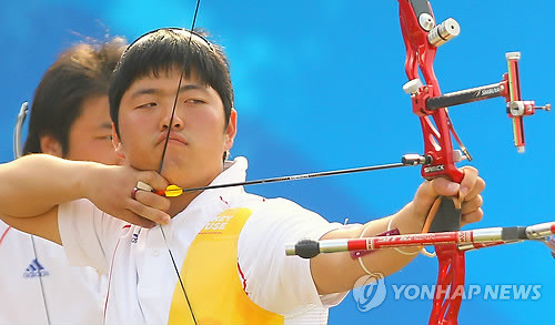 ▲ 22일 중국 광저우 아오티 양궁장에서 열린 2010 광저우 아시안게임 남자 양궁 단체전 4강 인도와의 경기에서 한국의 김우진이 금메달을 향한 활시위를 당기고 있다. ⓒ연합뉴스