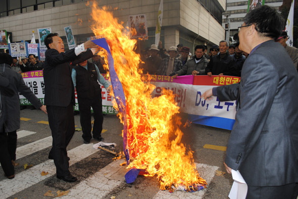 ▲ 시민단체 회원들은 인공기와 김정일사진을 불에 태우는 퍼포먼스를 진행하고 있다. ⓒ 뉴데일리