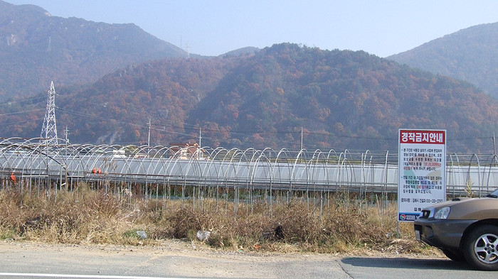 ▲ 경남 낙동강사업 7공구 김해 매리지구 현장. 낙동강이 갑자기 좁아지는 곳으로 비닐하우스 등이 보이는 곳이 하천구역에 편입된 곳이다. 마을이 형성돼 그동안 보상이 늦어졌지만 정부의 사업권 회수 이후 협의가 본격화되고 있다.