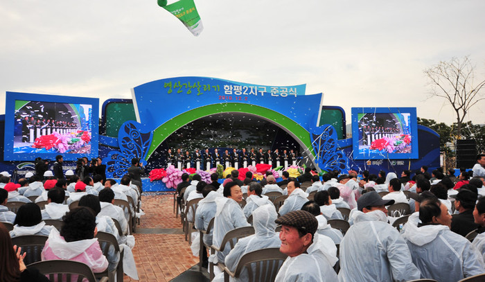 ▲ 함평2지구 준공식에서 초청자들이 폭죽스위치를 누른뒤 좌석 뒤쪽으로 피어오르는 조형물을 보기위해 돌아보고 있다.