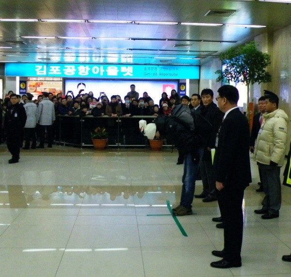 ▲ 19일 오전 11시경 김포공항에 도착한 신정환이 취재진과 팬들을 향해 90도로 허리를 숙여 사과의 인사를 하고 있다. ⓒ 뉴데일리