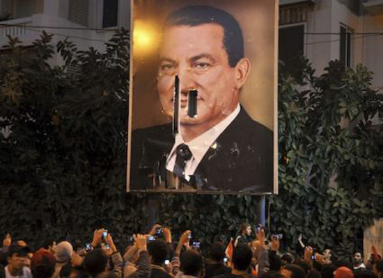 ▲ 호스니 무바라크 대통령의 초상화를 갈기갈기 찢은 후 기념사진을 찍는 시위대. 이란 혁명이 오버랩된다.ⓒ