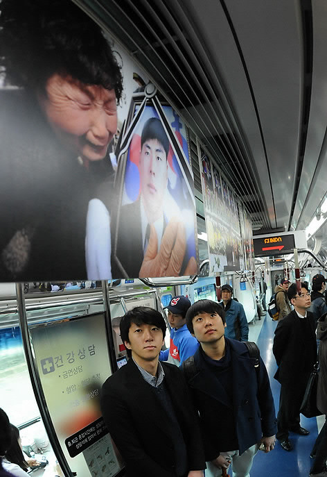 ▲ 20일 경기도민원전철에 마련된 천안함 1주기 추모사진전을 대학생들이 바라보고 있다. ⓒ 연합뉴스