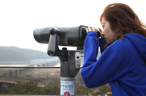 ▲ 경기도 기자단으로 뭉친 남한 대학생과 탈북한 새터민들이 캠프를 열었다. 이번 캠프에 참가한 한 남한 여대생이 파주 임진각에서 망원경으로 북녘을 바라보고 있다. ⓒ 뉴데일리