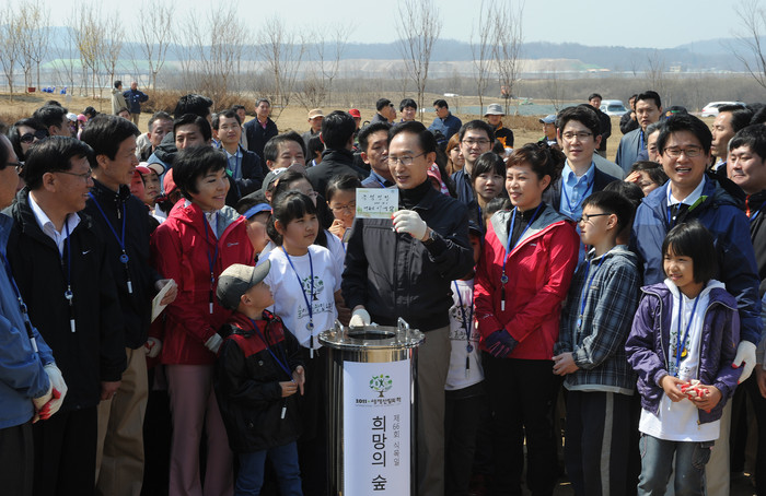 ▲ 이명박 대통령이 5일 오전 경기도 여주군 대신면 남한강 수변지역에서 가진 식목일 행사에서 타임캡슐을 묻기전에 '녹색성장'이라는 글자를 들어보이고 있다. ⓒ이오봉 뉴데일리 기자