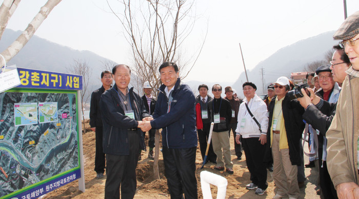 ▲ 강촌 문인상징조형물 예정지에서 기념식수를 하기위해 찾아온 문인들. 정종명 한국문인협회장(왼쪽)이 정병윤 원주지방국토청장에게 감사의 인사를 하고 있다.