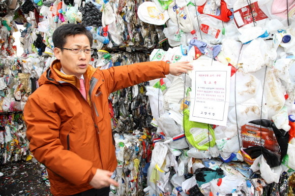 ▲ 고양시 최성 시장이 덕양구 현천동에 소재한 불법 시설물 마포구폐기물처리시설에 경고장을 붙이고 있다.ⓒ뉴데일리