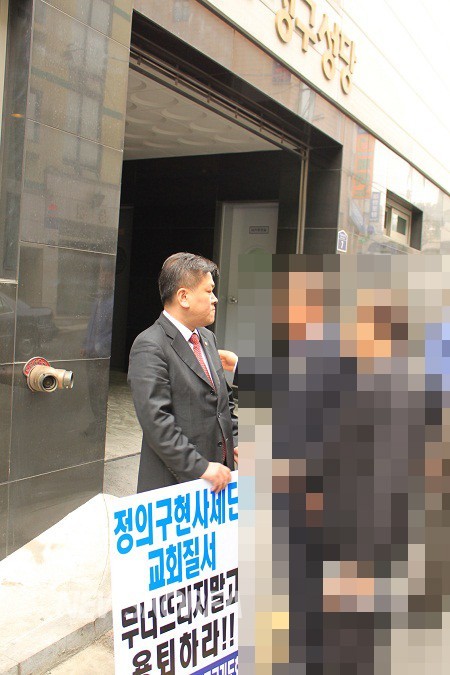 ▲ 10일 오전 서울 중구 신당동 청구성당 앞에서 한국가톨릭나라사랑기도회(이하 기도회) 회원이 정의구현사제단(이하 정구사)의 ‘용퇴’를 요구하며 1인 시위를 벌이고 있다. ⓒ뉴스코리아