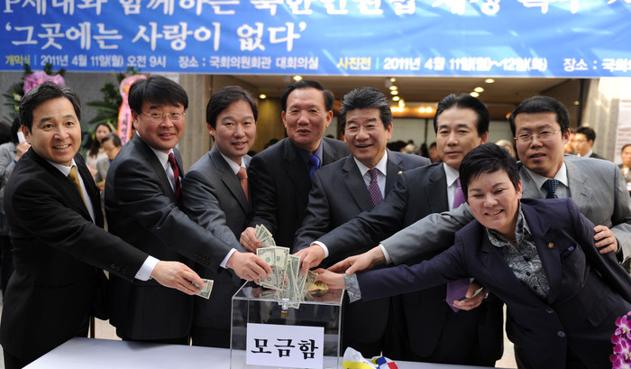 ▲ 11일 국회의원회관에서 열린 북한인권사진전에 참석한 국회의원 및 관계자들이 부대행사로 마련된 '1달러 모으기 운동'에 참여하고 있다. (좌측부터 한나라당 심재철, 조전혁, 신지호, 박상은, 강석호, 나성린 의원, 정 베드로 목사, 미래희망연대 송영선 의원 ⓒ추진혁 기자