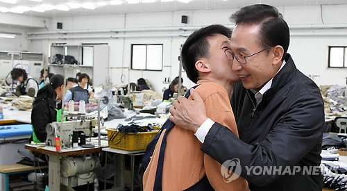 ▲ 장애인 근로자로부터 기습 '볼 키스'를 받고 있는 이명박 대통령.ⓒ연합뉴스