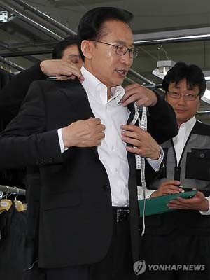 ▲ 장애인 고용 우수기업에서 신사복을 맞춰 입고 있는 이명박 대통령.ⓒ연합뉴스