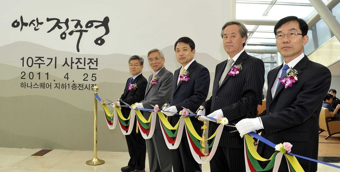 ▲ 25일 고려대학교 안암캠퍼스 하나스퀘어 전시관에서 열린 정주영 명예회장의 추모 사진전에 참가한 참가자들이 전시회 개막을 알리는 테이프 커팅을 하는 모습