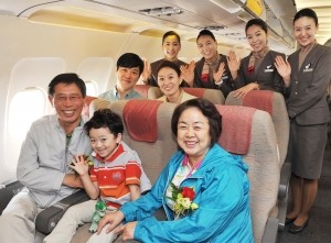 ▲ 아시아나 '효(孝) 서비스'를 통해 선호좌석을 배정받은 부모님 동반 탑승객들이 기내에서 아시아나 승무원들과 기념촬영을 하고 있다.