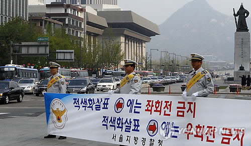 ▲ 서울지방경찰청 소속 경찰관들이 지난달 25일 오전 서울 광화문 4거리에서 새로운 신호 체계인 '3색 신호등'의 신호 준수를 홍보하고 있다. ⓒ 연합뉴스