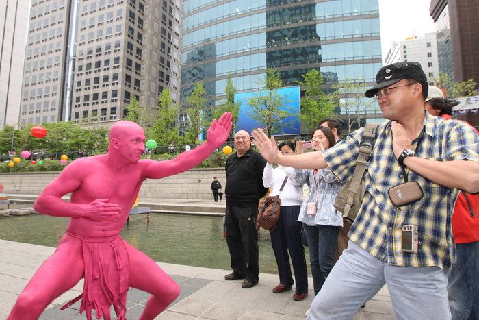 ▲ 서울 청계광장에 펼쳐진 '핑크 외계인의 침공'이라는 퍼포먼스 행사에 외국인 관람객이 똑같은 자세를 흉내내며 즐거워하고 있다. ⓒ  뉴데일리