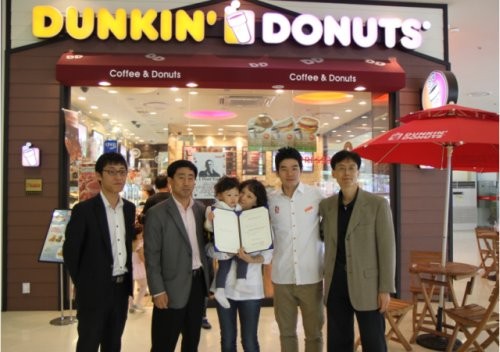 ▲ 정소향씨가 가은이와 함께 던킨도너츠 정식사원 채용확인서를 들며 환하게 미소 짓고 있다.ⓒ던킨도너츠 제공