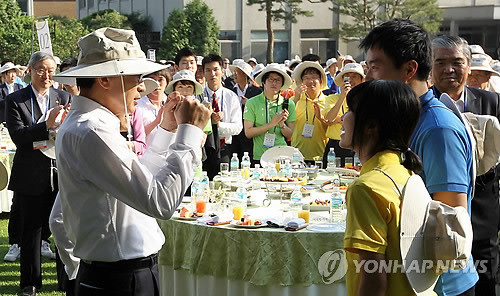 ▲ 이명박 대통령이 23일 오후 청와대 녹지원에서 열린 해외봉사단원 초청 행사에서 봉사단원에게 팬던트를 걸어준 후 두 주먹을 들어올리며 격려하고 있다.ⓒ연합뉴스