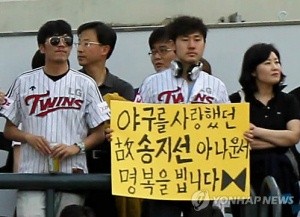 ▲ 24일 오후 서울 잠실야구장에서 열린 2011 프로야구 LG-두산의 경기. 관중석에서 LG 한 팬이 故 송지선 아나운서의 명복을 비는 피켓을 들고 있다.  ⓒ 연합뉴스