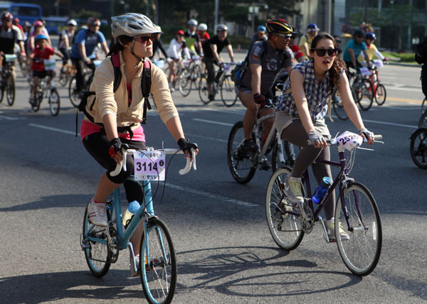 ▲ 시원한 복장으로 자전거대행진에 참여하고 있는 여성 참가자들ⓒ노용헌기자