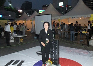 ▲ 노무현 전 대통령의 추모제에서 한명숙 민주당 상임고문이 태극기를 밝고 선 모습.ⓒ자료사진