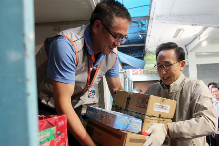 ▲ 이명박 대통령이 23일 서울 마포 한진택배터미널에서 국민경제대책회의를 가진 뒤 택배기사들과 함께 화물을 나르고 있다.ⓒ청와대