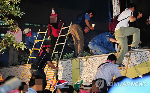 ▲ 부산=연합뉴스) = 12일 새벽 부산 영도구 봉래동 한진중공업 영도조선소 동문 쪽에서 '희망의 버스' 행사에 참여한 노동단체원들이 사다리를 타고 조선소 안으로 진입하고 있다. 2011.6.12 << 국제신문 제공 >>ⓒ