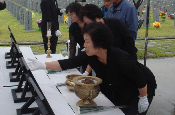 ▲ 고 조천형 중사의 어머니가 안타까운 손길로 영정 사진을 쓰다듬고 있다.ⓒ뉴데일리