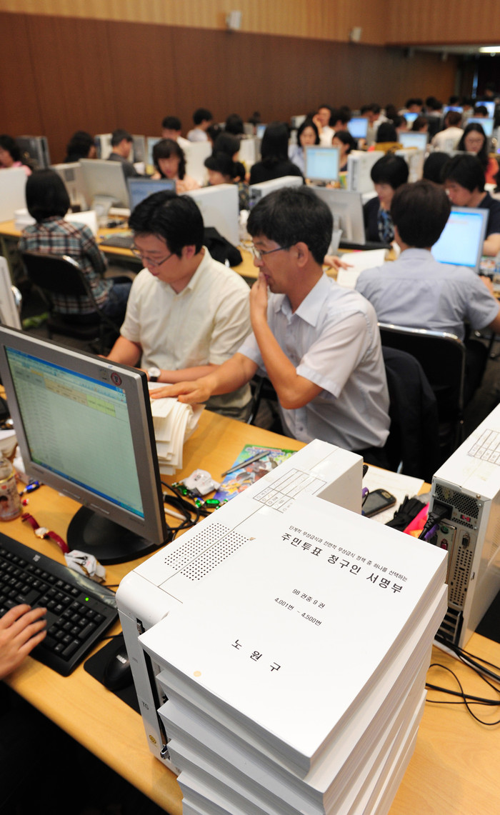 ▲ 30일 오후 서울시청 다산플라자 13층에 마련된 주민투표 서명확인장에서 서울시 직원들이 서명자와 주민등록번호를 컴퓨터에 입력하고 있다. ⓒ 뉴데일리