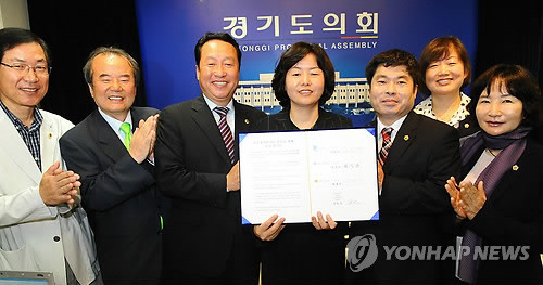 ▲ 4일 오전 경기도의회 기자실에서 경기도 학교용지분담금 실무협의회 김유임(왼쪽에서 4번째) 위원장 등 협의회 참가자들이 경기도와 경기도교육청이 6년간 갈등을 빚었던 학교용지 매입비 분담금 문제를 해결하는 공동 협력문을 들고 환하게 웃고 있다. ⓒ 연합뉴스