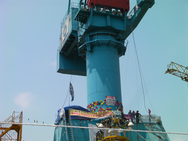 ▲ 김진숙 민노총 부산지부 지도위원이 점거농성을 벌이고 있는 타워크레인. 중간에 민노총 소속원 7~8명이 있고 위 철탑같은 곳에 김진숙 위원이 '거주' 중이다.