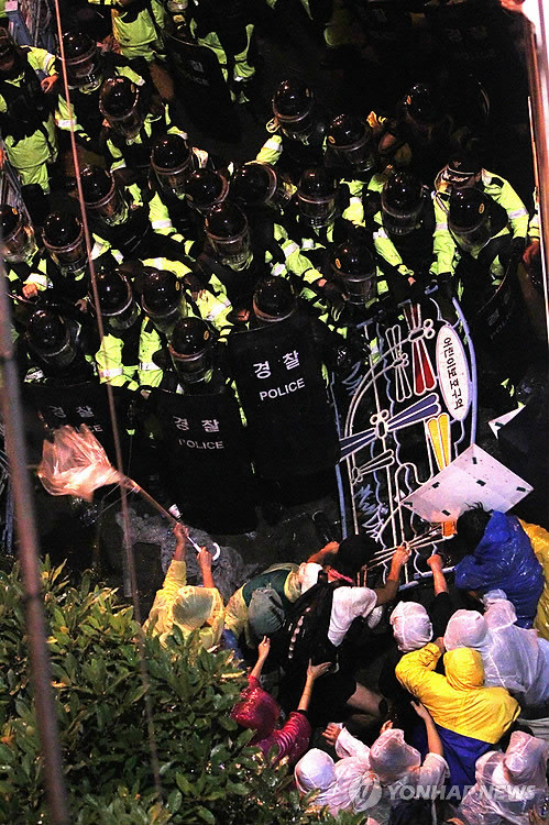 ▲ (부산=연합뉴스) 김선호 기자 = 2차 '희망의 버스' 참가자들이 9일 밤 한진중공업 영도조선소로 가려다 차벽으로 왕복 7차선 도로를 완전히 가로막힌 가운데 경찰과 몸싸움을 벌이고 있다ⓒ