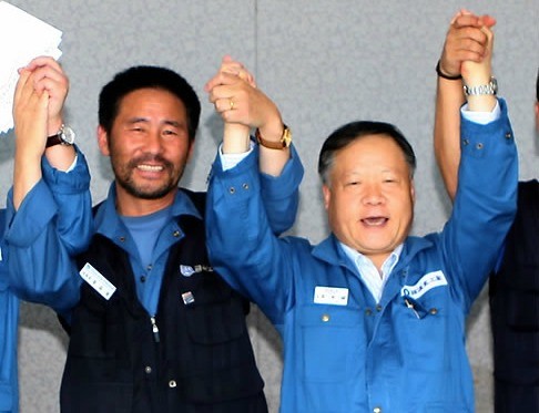 ▲ 한진중공업 노사협상이 지난달 27일 최종 타결된 가운데 이재용 한진중공업 조선부문 대표이사(오른쪽)와 채길용 금속노조 부산양산지부 한진중공업 지회장이 노사협의 이행합의서에 서명한 뒤 손을 들고 기념촬영을 하고 있다. ⓒ연합뉴스