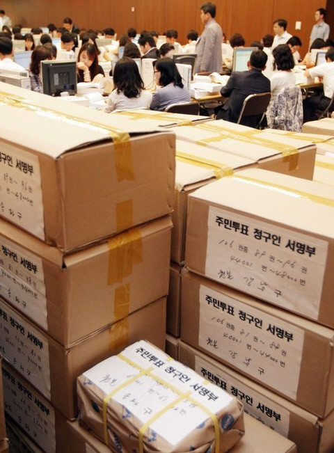 ▲ 서울시 직원들이 세금급식 반대를 주장하는 시민들의 서명부를 앞에 두고 검증작업을 벌이고 있다. ⓒ 뉴데일리