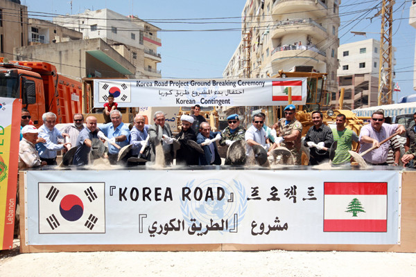 ▲ 7월 16일 동명부대와 지역 주민들이 '코리안로드' 준공식에서 삽으로 모래를 뿌리고 있다.