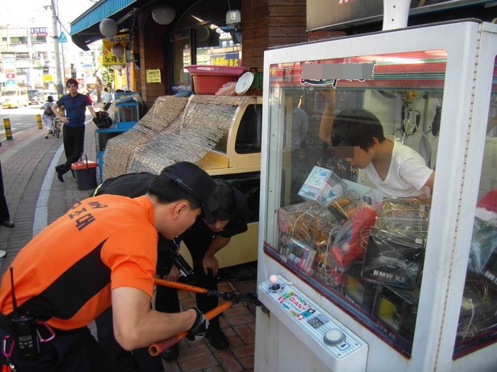 ▲ 사고 현장 모습. 119 구조대원이 장비로 인형뽑기 기계에 걸린 자물쇠를 절단기로 자르고 갇혀 있던 어린이를 구조했다.ⓒ경기소방재난본부 제공