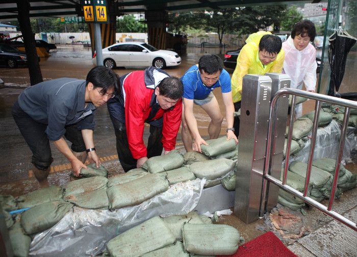 ▲ 27일 서울메트로 직원들이 침수에 대비해 지하철 역 입구에 모래주머니를 쌓고 있다. ⓒ 서울메트로 제공