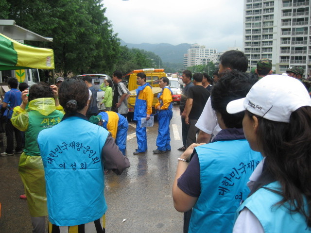 ▲ 우면산 일대 수해복구 현장을 찾은 재향군인회 회원들이 봉사자들에게 먹을거리를 나눠주고 있다.ⓒ 사진제공 재향군인회