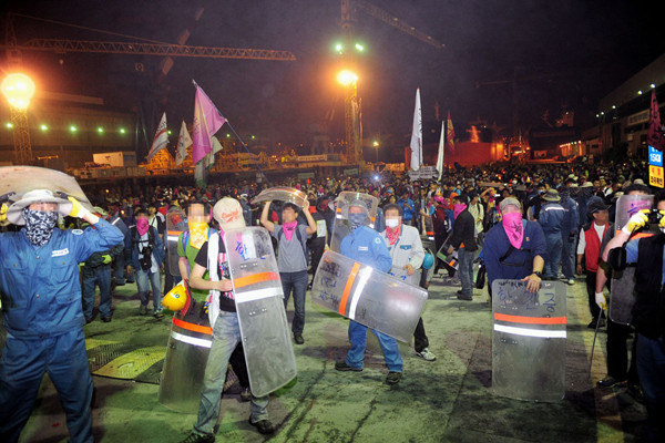 ▲ 지난 6월 11일과 12일 사이 한진중공업을 '습격'한 1차 희망버스 일행들의 모습. 쇠파이프로 용역 아르바이트생들을 구타한 뒤 방패를 뺏어든 채 서 있다.